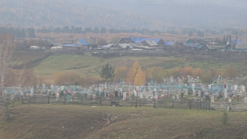 Sibirisches Dorf mit einem farbenfrohen Friedhof
