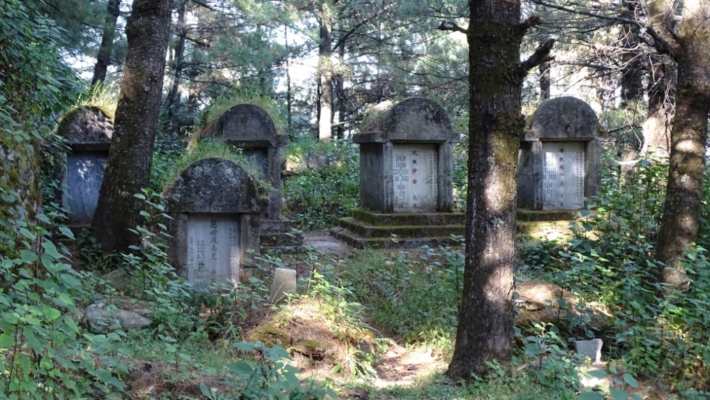 Der Wanderweg führt uns durch einen grossen Friedhof, der sich inmitten des Bergwaldes, hoch über Dali befindet