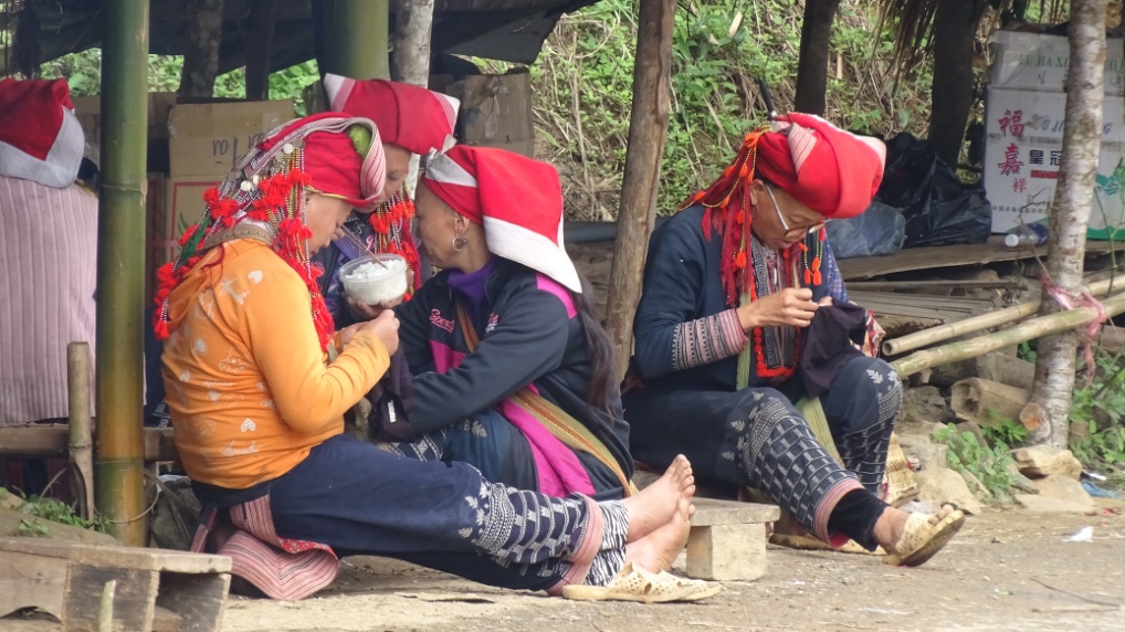 Vor dem Eingang zum Ressort arbeiten die Frauen an den Sachen, welche sie später an die Touristen verkaufen